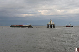 Sandheads Lighhouse With Barge And Tugboat