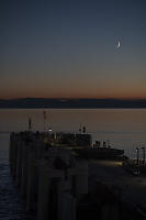 Moon Setting At Sunset Over Ferry Terminal