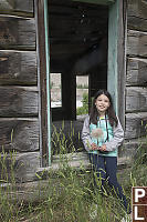 Claira Sitting In Log Home Window